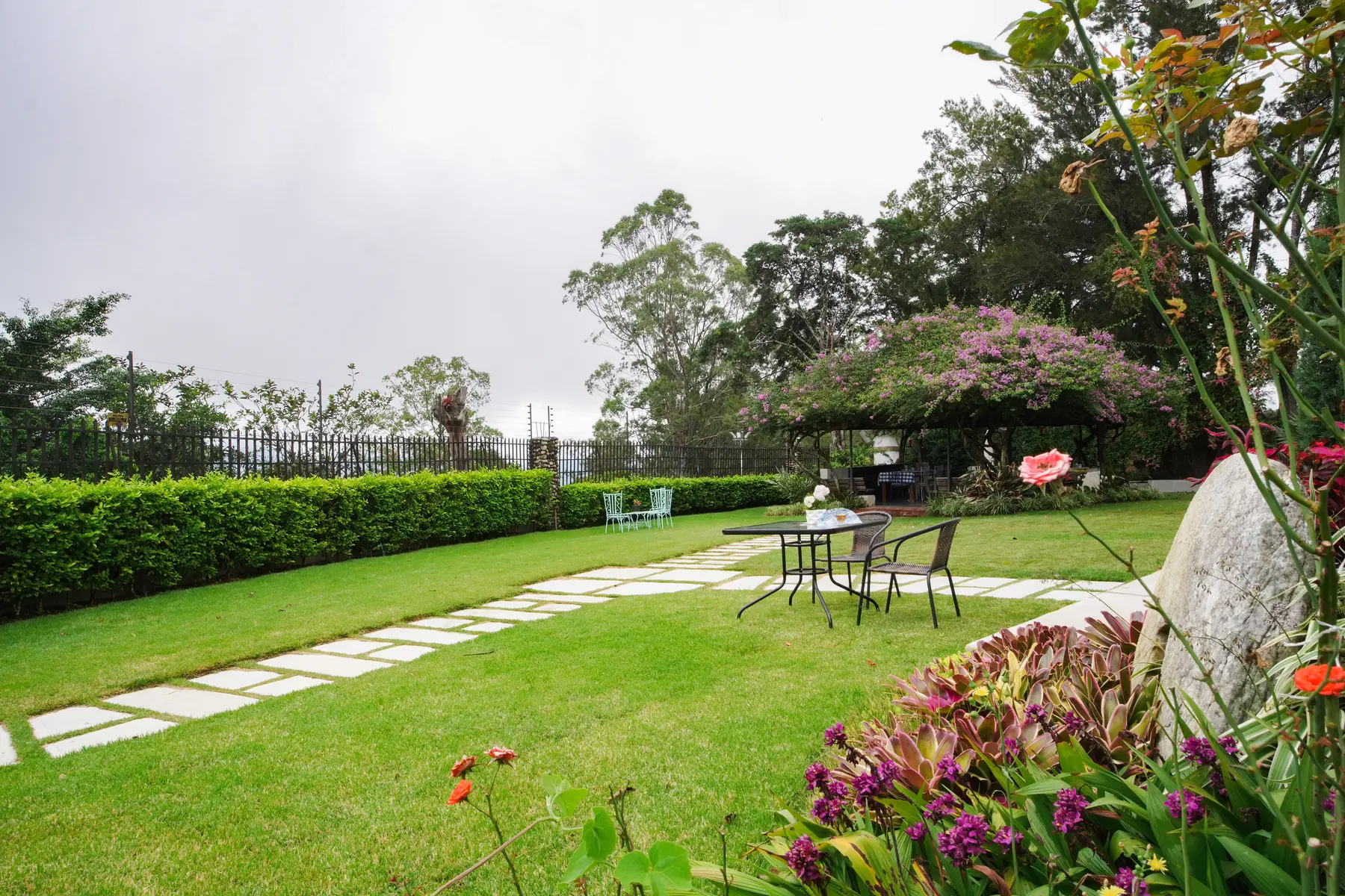 Jardín amplio con sendero y mesas